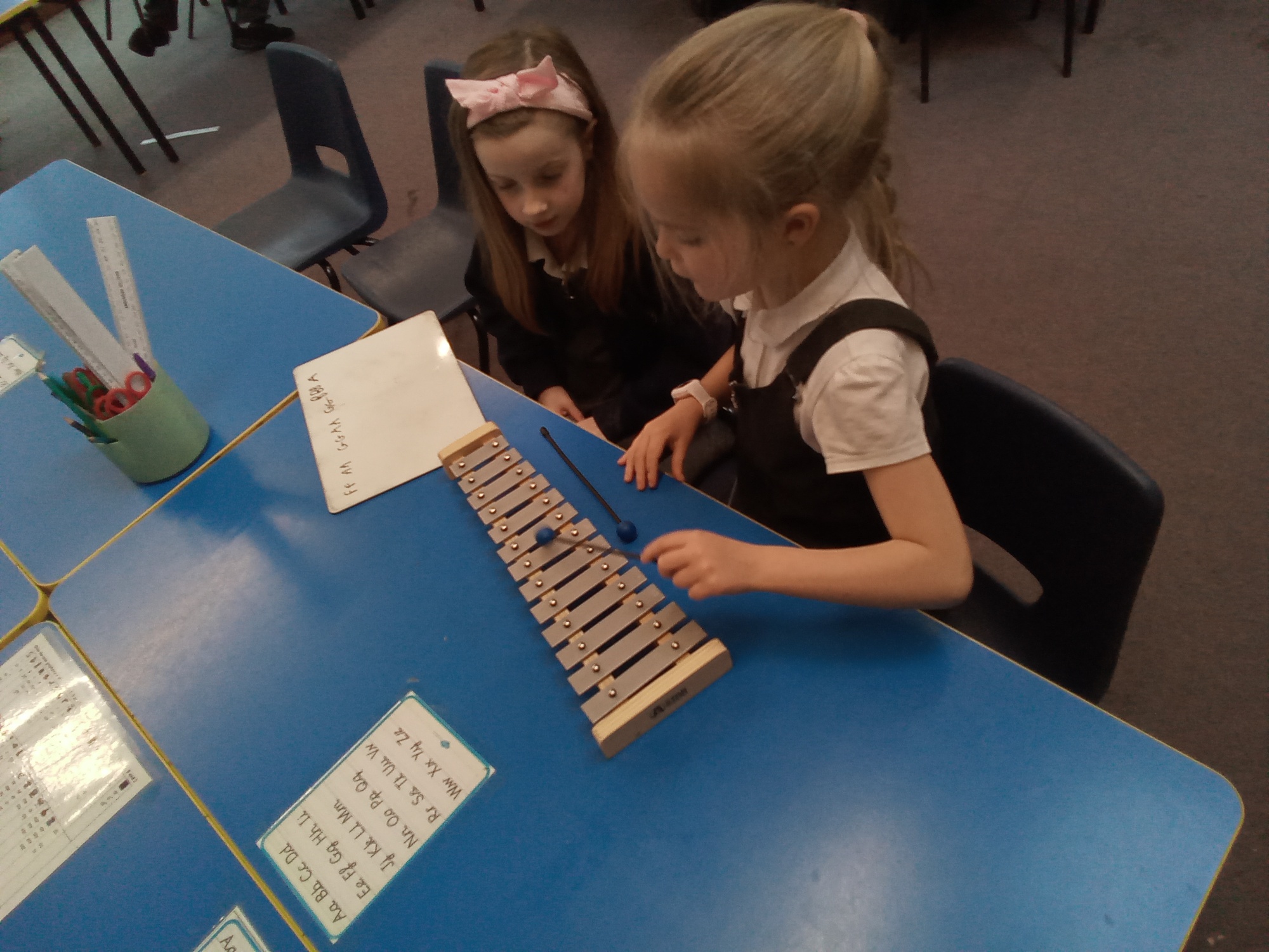 " children playing a glockenspiel in music lesson